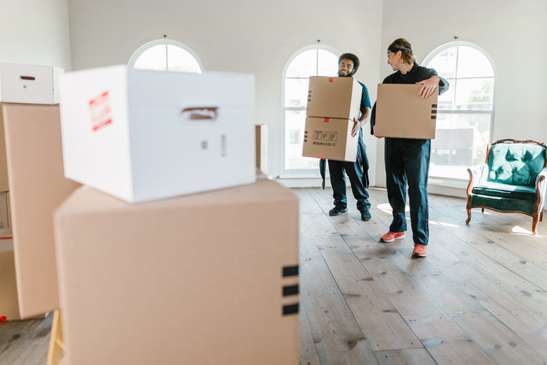 Two men carrying moving boxes.